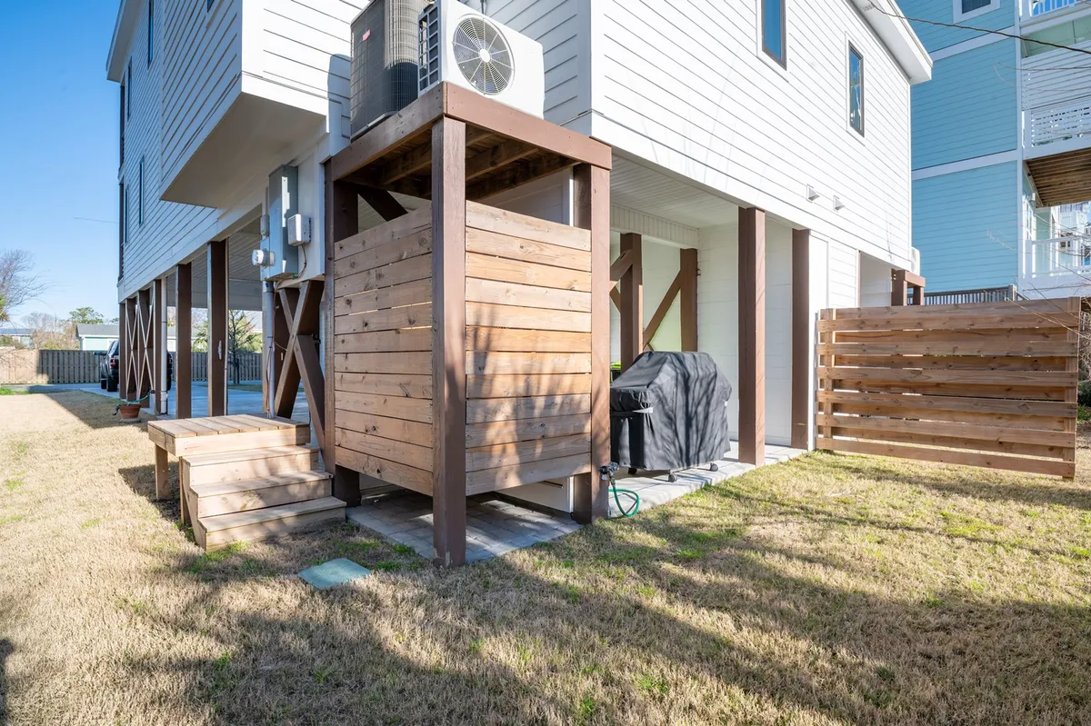 This image features a wooden grill enclosure and deck area with an outdoor grill, set up for casual gatherings. The deck is inviting for sunset dinners or socializing, with enough space to comfortably host a group. The overall ambiance is relaxed and social, ideal for evening get-togethers.