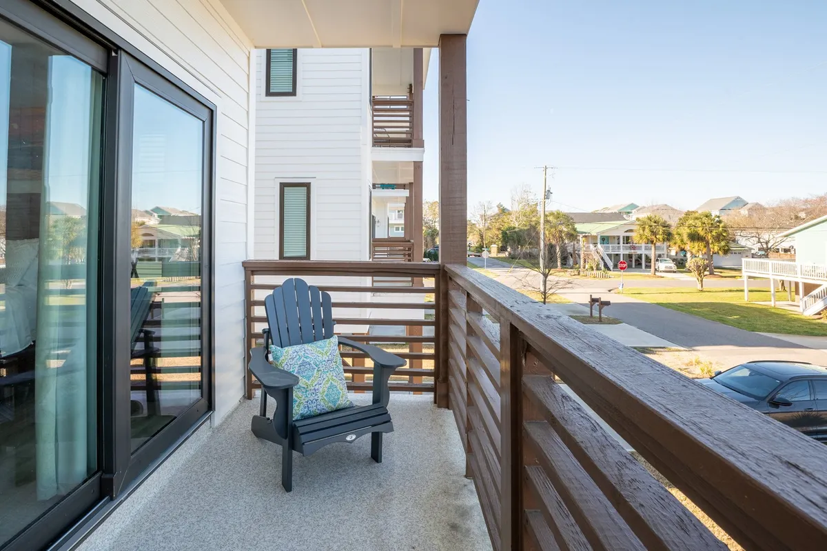 A serene balcony scene with an Adirondack chair, decorative pillow, and sturdy railing. The spot is perfect for enjoying a morning coffee, taking in sweeping island views, or sharing quiet moments with friends.